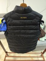 🉐 Arcteryx始祖鸟 Cerium Vest 纯色刺绣Logo字母 羽绒马甲 黑金

内里不是羽绒直接白送！
填充RDS认证850蓬欧洲白鹅绒，暖重比卓越，搭配易潮湿部位的Coreloft™合成 insulation，干冷湿冷环境均能持续保暖。 外层采用15D再生抗撕裂尼龙，整体轻盈可压缩，收纳后小于葡萄柚，随带随用。纯色基底搭配立体刺绣Logo，针脚工整清晰，品牌辨识度高。立体剪裁设计无活动束缚，可作为户外中层保暖件，也能当城市通勤叠穿单品，适配春秋冬三季穿搭需求。配备YKK防水拉链、可调抽绳下摆。

现货尺码：M、L、XL、XXL 。（可穿100-200斤 报身高体重安排合适尺码） - Image 8