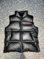 高绒 mu
顶级版本PRADA鸭绒羽绒马甲、
重磅牛货
年度最为昂贵的一款羽绒
同质GT的品控细节，超级震憾
绝对是今年羽绒翘楚数一数二！
内填充90白鹅绒 ，回弹性与保暖性兼圣品！
这款采用国内客供顶级的尼龙织物面料
面料表面的光泽感极强色泽油亮，尼龙织物的材质柔软手感巨好。全身防水压胶工艺！所有拼接全部采用压胶工艺，全方位防水！衣身质地轻盈兼具功能性，透过内衬细节的压胶条能看出此款的重工所在。
门襟拉链位置内衬口袋侧边条下侧口袋等多处细节，都需要重工进行的技术处理
胸前左侧红色压胶条字母标识点缀，提亮衣身整体格调，打造出本季P独特色彩搭配美学，低调而不张扬的穿着风格
尺码：M-3Xl - Image 5