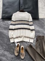 🆕- This knitted sweater weaves a Mediterranean breeze into the wardrobeWhen 10 cotton yarns and 46 blended yarns meet on a seven needle jacquard machine, the three yarns begin to weave a dialogue about material and color. Navy blue and navy blue cotton yarn have a rough and rustic feel, like the late night waters of the Adriatic Sea; The addition of 3.7% mulberry silk and wool in the light camel colored blended yarn gives the striped edges a subtle luster, reminiscent of the sparkling waves at sunset in Venice.When the weight of 580 grams is unfolded in the hand, one can feel the delicate balance between the stiffness of cotton and the softness of blended yarn. The vertical jacquard woven alternately with osmanthus needles and hanging needles forms a subtle texture on the navy blue background, resembling the outline of Venetian architecture seen through blinds. The white version is like a linen cloth sprinkled with sunlight, and the collision of the three materials is portrayed more clearly on a pure white canvas.The curvature of the round neck continues the elegant tradition of Italian tailoring, neither tightening the neck nor maintaining sharp lines. The contraction process of the hem keeps the hem of the garment firmly attached to the waist, and it will not move up whether you lift your hand or turn around. To support the muscles and bones with 10 strands of cotton yarn, to outline with delicate 46 strands of blended yarn, and to add luster and mulberry silk embellishment - this knitted sweater weaves the advantages of different materials into the same picture.The navy blue version paired with white pants is a classic Mediterranean style, while the white version paired with dark gray trousers can instantly switch to Milan style urban elegance. The intentions hidden in the texture of osmanthus needles, yarn blending, and precise weight all need to be personally felt in the cool autumn breeze to fully understand. While others are still struggling with the basic knitwear, this three layered jacquard sweater has already captivated the eyes of those who understand it with its sense of layering.In the current era of fast fashion proliferation, a blend knit that becomes softer and skin friendly with increasing wear is the truly worthwhile wardrobe evergreen tree to invest in. Jay Ya uses this piece to prove that a sophisticated sense of leisure allows every material to find the most comfortable expression in fabric.Color: White navy blue174-140 upper body size LSize: M-XXXL (48-56)Style number: FXZZ8688M size bust circumference 104 shoulder width 46.5 sleeve length 56 garment length 64.5Size L Chest circumference 108 Shoulder width 48 Sleeve length 57 Clothing length 66XL bust circumference 112 shoulder width 49.5 sleeve length 58 garment length 67.5XXL chest circumference 116 shoulder width 51 sleeve length 59 garment length 68.5XXXL bust circumference 120 shoulder width 52.5 sleeve length 60 garment length 69.5 - Image 3