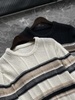 🆕- This knitted sweater weaves a Mediterranean breeze into the wardrobeWhen 10 cotton yarns and 46 blended yarns meet on a seven needle jacquard machine, the three yarns begin to weave a dialogue about material and color. Navy blue and navy blue cotton yarn have a rough and rustic feel, like the late night waters of the Adriatic Sea; The addition of 3.7% mulberry silk and wool in the light camel colored blended yarn gives the striped edges a subtle luster, reminiscent of the sparkling waves at sunset in Venice.When the weight of 580 grams is unfolded in the hand, one can feel the delicate balance between the stiffness of cotton and the softness of blended yarn. The vertical jacquard woven alternately with osmanthus needles and hanging needles forms a subtle texture on the navy blue background, resembling the outline of Venetian architecture seen through blinds. The white version is like a linen cloth sprinkled with sunlight, and the collision of the three materials is portrayed more clearly on a pure white canvas.The curvature of the round neck continues the elegant tradition of Italian tailoring, neither tightening the neck nor maintaining sharp lines. The contraction process of the hem keeps the hem of the garment firmly attached to the waist, and it will not move up whether you lift your hand or turn around. To support the muscles and bones with 10 strands of cotton yarn, to outline with delicate 46 strands of blended yarn, and to add luster and mulberry silk embellishment - this knitted sweater weaves the advantages of different materials into the same picture.The navy blue version paired with white pants is a classic Mediterranean style, while the white version paired with dark gray trousers can instantly switch to Milan style urban elegance. The intentions hidden in the texture of osmanthus needles, yarn blending, and precise weight all need to be personally felt in the cool autumn breeze to fully understand. While others are still struggling with the basic knitwear, this three layered jacquard sweater has already captivated the eyes of those who understand it with its sense of layering.In the current era of fast fashion proliferation, a blend knit that becomes softer and skin friendly with increasing wear is the truly worthwhile wardrobe evergreen tree to invest in. Jay Ya uses this piece to prove that a sophisticated sense of leisure allows every material to find the most comfortable expression in fabric.Color: White navy blue174-140 upper body size LSize: M-XXXL (48-56)Style number: FXZZ8688M size bust circumference 104 shoulder width 46.5 sleeve length 56 garment length 64.5Size L Chest circumference 108 Shoulder width 48 Sleeve length 57 Clothing length 66XL bust circumference 112 shoulder width 49.5 sleeve length 58 garment length 67.5XXL chest circumference 116 shoulder width 51 sleeve length 59 garment length 68.5XXXL bust circumference 120 shoulder width 52.5 sleeve length 60 garment length 69.5 - Image 4