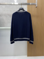 Prada wool blend knit sweater1. Wool and cashmere blended fabric:Selected high-quality wool and cashmere raw materials are blended in a certain proportion. Wool provides warmth and durability, while cashmere gives clothing a soft and delicate touch, making the fabric both comfortable and practical. Different from market products, our sweaters have a softer and more sticky texture2. Yarn preparationYarn dyeing and binding: Analyze the binding of yarn in the original version to ensure color reproduction and good color fastness.Yarn quality inspection: Conduct strict quality inspections on the yarn, including indicators such as line density, evenness, and moisture regain, to ensure that the yarn quality meets production standards.3. Knitted knittingUsing advanced knitting and weaving equipment to weave blended yarn into knitted shirts. During the weaving process, it is necessary to precisely control parameters such as knitting density and pattern changes to ensure the quality and appearance of the finished product. The precision of restoring the knight pattern4. Detail decoration and logo treatmentRibbed Knitted Decoration: Ribbed knitted decoration is used on the collar, cuffs, and hem of knitted shirts to enhance the beauty of details and make the clothing more in line with the body shape.Logo processing: Fix the Equestrian Knight logo (EKD) and Burberry lettering logo onto a knitted sweater through knitting. These logos enhance the recognition of clothing.5. Post sorting and inspectionShrinking treatment: Using the shrinking characteristics of cashmere fibers to shrink knitted sweaters.Ironing and shaping: Ironing knitwear to make it flatter, firmer, and maintain its style characteristics. Accurate temperature and pressure control is required during the ironing process to prevent clothing deformation or damage.Size: M-xxl - Image 8