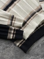 🆕- This knitted sweater weaves a Mediterranean breeze into the wardrobeWhen 10 cotton yarns and 46 blended yarns meet on a seven needle jacquard machine, the three yarns begin to weave a dialogue about material and color. Navy blue and navy blue cotton yarn have a rough and rustic feel, like the late night waters of the Adriatic Sea; The addition of 3.7% mulberry silk and wool in the light camel colored blended yarn gives the striped edges a subtle luster, reminiscent of the sparkling waves at sunset in Venice.When the weight of 580 grams is unfolded in the hand, one can feel the delicate balance between the stiffness of cotton and the softness of blended yarn. The vertical jacquard woven alternately with osmanthus needles and hanging needles forms a subtle texture on the navy blue background, resembling the outline of Venetian architecture seen through blinds. The white version is like a linen cloth sprinkled with sunlight, and the collision of the three materials is portrayed more clearly on a pure white canvas.The curvature of the round neck continues the elegant tradition of Italian tailoring, neither tightening the neck nor maintaining sharp lines. The contraction process of the hem keeps the hem of the garment firmly attached to the waist, and it will not move up whether you lift your hand or turn around. To support the muscles and bones with 10 strands of cotton yarn, to outline with delicate 46 strands of blended yarn, and to add luster and mulberry silk embellishment - this knitted sweater weaves the advantages of different materials into the same picture.The navy blue version paired with white pants is a classic Mediterranean style, while the white version paired with dark gray trousers can instantly switch to Milan style urban elegance. The intentions hidden in the texture of osmanthus needles, yarn blending, and precise weight all need to be personally felt in the cool autumn breeze to fully understand. While others are still struggling with the basic knitwear, this three layered jacquard sweater has already captivated the eyes of those who understand it with its sense of layering.In the current era of fast fashion proliferation, a blend knit that becomes softer and skin friendly with increasing wear is the truly worthwhile wardrobe evergreen tree to invest in. Jay Ya uses this piece to prove that a sophisticated sense of leisure allows every material to find the most comfortable expression in fabric.Color: White navy blue174-140 upper body size LSize: M-XXXL (48-56)Style number: FXZZ8688M size bust circumference 104 shoulder width 46.5 sleeve length 56 garment length 64.5Size L Chest circumference 108 Shoulder width 48 Sleeve length 57 Clothing length 66XL bust circumference 112 shoulder width 49.5 sleeve length 58 garment length 67.5XXL chest circumference 116 shoulder width 51 sleeve length 59 garment length 68.5XXXL bust circumference 120 shoulder width 52.5 sleeve length 60 garment length 69.5 - Image 6