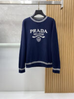 Prada wool blend knit sweater1. Wool and cashmere blended fabric:Selected high-quality wool and cashmere raw materials are blended in a certain proportion. Wool provides warmth and durability, while cashmere gives clothing a soft and delicate touch, making the fabric both comfortable and practical. Different from market products, our sweaters have a softer and more sticky texture2. Yarn preparationYarn dyeing and binding: Analyze the binding of yarn in the original version to ensure color reproduction and good color fastness.Yarn quality inspection: Conduct strict quality inspections on the yarn, including indicators such as line density, evenness, and moisture regain, to ensure that the yarn quality meets production standards.3. Knitted knittingUsing advanced knitting and weaving equipment to weave blended yarn into knitted shirts. During the weaving process, it is necessary to precisely control parameters such as knitting density and pattern changes to ensure the quality and appearance of the finished product. The precision of restoring the knight pattern4. Detail decoration and logo treatmentRibbed Knitted Decoration: Ribbed knitted decoration is used on the collar, cuffs, and hem of knitted shirts to enhance the beauty of details and make the clothing more in line with the body shape.Logo processing: Fix the Equestrian Knight logo (EKD) and Burberry lettering logo onto a knitted sweater through knitting. These logos enhance the recognition of clothing.5. Post sorting and inspectionShrinking treatment: Using the shrinking characteristics of cashmere fibers to shrink knitted sweaters.Ironing and shaping: Ironing knitwear to make it flatter, firmer, and maintain its style characteristics. Accurate temperature and pressure control is required during the ironing process to prevent clothing deformation or damage.Size: M-xxl