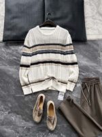 🆕- This knitted sweater weaves a Mediterranean breeze into the wardrobeWhen 10 cotton yarns and 46 blended yarns meet on a seven needle jacquard machine, the three yarns begin to weave a dialogue about material and color. Navy blue and navy blue cotton yarn have a rough and rustic feel, like the late night waters of the Adriatic Sea; The addition of 3.7% mulberry silk and wool in the light camel colored blended yarn gives the striped edges a subtle luster, reminiscent of the sparkling waves at sunset in Venice.When the weight of 580 grams is unfolded in the hand, one can feel the delicate balance between the stiffness of cotton and the softness of blended yarn. The vertical jacquard woven alternately with osmanthus needles and hanging needles forms a subtle texture on the navy blue background, resembling the outline of Venetian architecture seen through blinds. The white version is like a linen cloth sprinkled with sunlight, and the collision of the three materials is portrayed more clearly on a pure white canvas.The curvature of the round neck continues the elegant tradition of Italian tailoring, neither tightening the neck nor maintaining sharp lines. The contraction process of the hem keeps the hem of the garment firmly attached to the waist, and it will not move up whether you lift your hand or turn around. To support the muscles and bones with 10 strands of cotton yarn, to outline with delicate 46 strands of blended yarn, and to add luster and mulberry silk embellishment - this knitted sweater weaves the advantages of different materials into the same picture.The navy blue version paired with white pants is a classic Mediterranean style, while the white version paired with dark gray trousers can instantly switch to Milan style urban elegance. The intentions hidden in the texture of osmanthus needles, yarn blending, and precise weight all need to be personally felt in the cool autumn breeze to fully understand. While others are still struggling with the basic knitwear, this three layered jacquard sweater has already captivated the eyes of those who understand it with its sense of layering.In the current era of fast fashion proliferation, a blend knit that becomes softer and skin friendly with increasing wear is the truly worthwhile wardrobe evergreen tree to invest in. Jay Ya uses this piece to prove that a sophisticated sense of leisure allows every material to find the most comfortable expression in fabric.Color: White navy blue174-140 upper body size LSize: M-XXXL (48-56)Style number: FXZZ8688M size bust circumference 104 shoulder width 46.5 sleeve length 56 garment length 64.5Size L Chest circumference 108 Shoulder width 48 Sleeve length 57 Clothing length 66XL bust circumference 112 shoulder width 49.5 sleeve length 58 garment length 67.5XXL chest circumference 116 shoulder width 51 sleeve length 59 garment length 68.5XXXL bust circumference 120 shoulder width 52.5 sleeve length 60 garment length 69.5