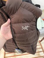 🉐 Arcteryx始祖鸟 Cerium Vest 纯色刺绣Logo字母 羽绒马甲 绒砂棕

内里不是羽绒直接白送！
填充RDS认证850蓬欧洲白鹅绒，暖重比卓越，搭配易潮湿部位的Coreloft™合成 insulation，干冷湿冷环境均能持续保暖。 外层采用15D再生抗撕裂尼龙，整体轻盈可压缩，收纳后小于葡萄柚，随带随用￼￼￼。纯色基底搭配立体刺绣Logo，针脚工整清晰，品牌辨识度高。立体剪裁设计无活动束缚，可作为户外中层保暖件，也能当城市通勤叠穿单品，适配春秋冬三季穿搭需求。配备YKK防水拉链、可调抽绳下摆。

现货尺码：M、L、XL、XXL 。（可穿100-200斤 报身高体重安排合适尺码） - Image 3