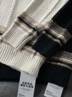 🆕- This knitted sweater weaves a Mediterranean breeze into the wardrobeWhen 10 cotton yarns and 46 blended yarns meet on a seven needle jacquard machine, the three yarns begin to weave a dialogue about material and color. Navy blue and navy blue cotton yarn have a rough and rustic feel, like the late night waters of the Adriatic Sea; The addition of 3.7% mulberry silk and wool in the light camel colored blended yarn gives the striped edges a subtle luster, reminiscent of the sparkling waves at sunset in Venice.When the weight of 580 grams is unfolded in the hand, one can feel the delicate balance between the stiffness of cotton and the softness of blended yarn. The vertical jacquard woven alternately with osmanthus needles and hanging needles forms a subtle texture on the navy blue background, resembling the outline of Venetian architecture seen through blinds. The white version is like a linen cloth sprinkled with sunlight, and the collision of the three materials is portrayed more clearly on a pure white canvas.The curvature of the round neck continues the elegant tradition of Italian tailoring, neither tightening the neck nor maintaining sharp lines. The contraction process of the hem keeps the hem of the garment firmly attached to the waist, and it will not move up whether you lift your hand or turn around. To support the muscles and bones with 10 strands of cotton yarn, to outline with delicate 46 strands of blended yarn, and to add luster and mulberry silk embellishment - this knitted sweater weaves the advantages of different materials into the same picture.The navy blue version paired with white pants is a classic Mediterranean style, while the white version paired with dark gray trousers can instantly switch to Milan style urban elegance. The intentions hidden in the texture of osmanthus needles, yarn blending, and precise weight all need to be personally felt in the cool autumn breeze to fully understand. While others are still struggling with the basic knitwear, this three layered jacquard sweater has already captivated the eyes of those who understand it with its sense of layering.In the current era of fast fashion proliferation, a blend knit that becomes softer and skin friendly with increasing wear is the truly worthwhile wardrobe evergreen tree to invest in. Jay Ya uses this piece to prove that a sophisticated sense of leisure allows every material to find the most comfortable expression in fabric.Color: White navy blue174-140 upper body size LSize: M-XXXL (48-56)Style number: FXZZ8688M size bust circumference 104 shoulder width 46.5 sleeve length 56 garment length 64.5Size L Chest circumference 108 Shoulder width 48 Sleeve length 57 Clothing length 66XL bust circumference 112 shoulder width 49.5 sleeve length 58 garment length 67.5XXL chest circumference 116 shoulder width 51 sleeve length 59 garment length 68.5XXXL bust circumference 120 shoulder width 52.5 sleeve length 60 garment length 69.5 - Image 8