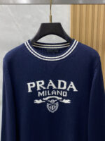 Prada wool blend knit sweater1. Wool and cashmere blended fabric:Selected high-quality wool and cashmere raw materials are blended in a certain proportion. Wool provides warmth and durability, while cashmere gives clothing a soft and delicate touch, making the fabric both comfortable and practical. Different from market products, our sweaters have a softer and more sticky texture2. Yarn preparationYarn dyeing and binding: Analyze the binding of yarn in the original version to ensure color reproduction and good color fastness.Yarn quality inspection: Conduct strict quality inspections on the yarn, including indicators such as line density, evenness, and moisture regain, to ensure that the yarn quality meets production standards.3. Knitted knittingUsing advanced knitting and weaving equipment to weave blended yarn into knitted shirts. During the weaving process, it is necessary to precisely control parameters such as knitting density and pattern changes to ensure the quality and appearance of the finished product. The precision of restoring the knight pattern4. Detail decoration and logo treatmentRibbed Knitted Decoration: Ribbed knitted decoration is used on the collar, cuffs, and hem of knitted shirts to enhance the beauty of details and make the clothing more in line with the body shape.Logo processing: Fix the Equestrian Knight logo (EKD) and Burberry lettering logo onto a knitted sweater through knitting. These logos enhance the recognition of clothing.5. Post sorting and inspectionShrinking treatment: Using the shrinking characteristics of cashmere fibers to shrink knitted sweaters.Ironing and shaping: Ironing knitwear to make it flatter, firmer, and maintain its style characteristics. Accurate temperature and pressure control is required during the ironing process to prevent clothing deformation or damage.Size: M-xxl - Image 2