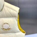 Mon蒙口（鹅绒）、2025秋冬新品 | MONCLE羽绒马甲。

米白色立领设计搭配顺滑拉链系统，正面采用100%锦纶防风面料，背面运用亮黄色轻量材质形成撞色美学。填充90%鹅绒与10%羽毛的黄金配比，绒朵蓬松度达600+FP，充绒量精准适配5℃至-5℃环境。左胸点缀经典立体刺绣徽章，两侧斜插口袋以隐藏式拉链保持流畅线条。

双面不同配色实现一衣多穿场景：米白面可搭配同色系针织衫演绎都市极简风，亮黄面翻转后瞬间提升视觉活力。立体剪裁确保活动自由度，台湾盟可睐有限公司精工制造，通过RN116347质量追溯体系。从防泼水锦纶到鹅绒填充，诠释蒙口将高山机能基因融入日常穿着的设计哲学。1-5码（模特173，143斤上身2码） - Image 4