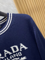 Prada wool blend knit sweater1. Wool and cashmere blended fabric:Selected high-quality wool and cashmere raw materials are blended in a certain proportion. Wool provides warmth and durability, while cashmere gives clothing a soft and delicate touch, making the fabric both comfortable and practical. Different from market products, our sweaters have a softer and more sticky texture2. Yarn preparationYarn dyeing and binding: Analyze the binding of yarn in the original version to ensure color reproduction and good color fastness.Yarn quality inspection: Conduct strict quality inspections on the yarn, including indicators such as line density, evenness, and moisture regain, to ensure that the yarn quality meets production standards.3. Knitted knittingUsing advanced knitting and weaving equipment to weave blended yarn into knitted shirts. During the weaving process, it is necessary to precisely control parameters such as knitting density and pattern changes to ensure the quality and appearance of the finished product. The precision of restoring the knight pattern4. Detail decoration and logo treatmentRibbed Knitted Decoration: Ribbed knitted decoration is used on the collar, cuffs, and hem of knitted shirts to enhance the beauty of details and make the clothing more in line with the body shape.Logo processing: Fix the Equestrian Knight logo (EKD) and Burberry lettering logo onto a knitted sweater through knitting. These logos enhance the recognition of clothing.5. Post sorting and inspectionShrinking treatment: Using the shrinking characteristics of cashmere fibers to shrink knitted sweaters.Ironing and shaping: Ironing knitwear to make it flatter, firmer, and maintain its style characteristics. Accurate temperature and pressure control is required during the ironing process to prevent clothing deformation or damage.Size: M-xxl - Image 4