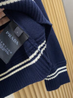 Prada wool blend knit sweater1. Wool and cashmere blended fabric:Selected high-quality wool and cashmere raw materials are blended in a certain proportion. Wool provides warmth and durability, while cashmere gives clothing a soft and delicate touch, making the fabric both comfortable and practical. Different from market products, our sweaters have a softer and more sticky texture2. Yarn preparationYarn dyeing and binding: Analyze the binding of yarn in the original version to ensure color reproduction and good color fastness.Yarn quality inspection: Conduct strict quality inspections on the yarn, including indicators such as line density, evenness, and moisture regain, to ensure that the yarn quality meets production standards.3. Knitted knittingUsing advanced knitting and weaving equipment to weave blended yarn into knitted shirts. During the weaving process, it is necessary to precisely control parameters such as knitting density and pattern changes to ensure the quality and appearance of the finished product. The precision of restoring the knight pattern4. Detail decoration and logo treatmentRibbed Knitted Decoration: Ribbed knitted decoration is used on the collar, cuffs, and hem of knitted shirts to enhance the beauty of details and make the clothing more in line with the body shape.Logo processing: Fix the Equestrian Knight logo (EKD) and Burberry lettering logo onto a knitted sweater through knitting. These logos enhance the recognition of clothing.5. Post sorting and inspectionShrinking treatment: Using the shrinking characteristics of cashmere fibers to shrink knitted sweaters.Ironing and shaping: Ironing knitwear to make it flatter, firmer, and maintain its style characteristics. Accurate temperature and pressure control is required during the ironing process to prevent clothing deformation or damage.Size: M-xxl - Image 7