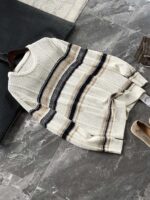 🆕- This knitted sweater weaves a Mediterranean breeze into the wardrobeWhen 10 cotton yarns and 46 blended yarns meet on a seven needle jacquard machine, the three yarns begin to weave a dialogue about material and color. Navy blue and navy blue cotton yarn have a rough and rustic feel, like the late night waters of the Adriatic Sea; The addition of 3.7% mulberry silk and wool in the light camel colored blended yarn gives the striped edges a subtle luster, reminiscent of the sparkling waves at sunset in Venice.When the weight of 580 grams is unfolded in the hand, one can feel the delicate balance between the stiffness of cotton and the softness of blended yarn. The vertical jacquard woven alternately with osmanthus needles and hanging needles forms a subtle texture on the navy blue background, resembling the outline of Venetian architecture seen through blinds. The white version is like a linen cloth sprinkled with sunlight, and the collision of the three materials is portrayed more clearly on a pure white canvas.The curvature of the round neck continues the elegant tradition of Italian tailoring, neither tightening the neck nor maintaining sharp lines. The contraction process of the hem keeps the hem of the garment firmly attached to the waist, and it will not move up whether you lift your hand or turn around. To support the muscles and bones with 10 strands of cotton yarn, to outline with delicate 46 strands of blended yarn, and to add luster and mulberry silk embellishment - this knitted sweater weaves the advantages of different materials into the same picture.The navy blue version paired with white pants is a classic Mediterranean style, while the white version paired with dark gray trousers can instantly switch to Milan style urban elegance. The intentions hidden in the texture of osmanthus needles, yarn blending, and precise weight all need to be personally felt in the cool autumn breeze to fully understand. While others are still struggling with the basic knitwear, this three layered jacquard sweater has already captivated the eyes of those who understand it with its sense of layering.In the current era of fast fashion proliferation, a blend knit that becomes softer and skin friendly with increasing wear is the truly worthwhile wardrobe evergreen tree to invest in. Jay Ya uses this piece to prove that a sophisticated sense of leisure allows every material to find the most comfortable expression in fabric.Color: White navy blue174-140 upper body size LSize: M-XXXL (48-56)Style number: FXZZ8688M size bust circumference 104 shoulder width 46.5 sleeve length 56 garment length 64.5Size L Chest circumference 108 Shoulder width 48 Sleeve length 57 Clothing length 66XL bust circumference 112 shoulder width 49.5 sleeve length 58 garment length 67.5XXL chest circumference 116 shoulder width 51 sleeve length 59 garment length 68.5XXXL bust circumference 120 shoulder width 52.5 sleeve length 60 garment length 69.5 - Image 2
