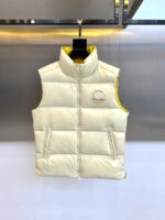 Mon蒙口（鹅绒）、2025秋冬新品 | MONCLE羽绒马甲。

米白色立领设计搭配顺滑拉链系统，正面采用100%锦纶防风面料，背面运用亮黄色轻量材质形成撞色美学。填充90%鹅绒与10%羽毛的黄金配比，绒朵蓬松度达600+FP，充绒量精准适配5℃至-5℃环境。左胸点缀经典立体刺绣徽章，两侧斜插口袋以隐藏式拉链保持流畅线条。

双面不同配色实现一衣多穿场景：米白面可搭配同色系针织衫演绎都市极简风，亮黄面翻转后瞬间提升视觉活力。立体剪裁确保活动自由度，台湾盟可睐有限公司精工制造，通过RN116347质量追溯体系。从防泼水锦纶到鹅绒填充，诠释蒙口将高山机能基因融入日常穿着的设计哲学。1-5码（模特173，143斤上身2码）
