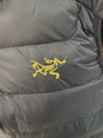 🉐 Arcteryx始祖鸟 Cerium Vest 纯色刺绣Logo字母 羽绒马甲 黑金

内里不是羽绒直接白送！
填充RDS认证850蓬欧洲白鹅绒，暖重比卓越，搭配易潮湿部位的Coreloft™合成 insulation，干冷湿冷环境均能持续保暖。 外层采用15D再生抗撕裂尼龙，整体轻盈可压缩，收纳后小于葡萄柚，随带随用。纯色基底搭配立体刺绣Logo，针脚工整清晰，品牌辨识度高。立体剪裁设计无活动束缚，可作为户外中层保暖件，也能当城市通勤叠穿单品，适配春秋冬三季穿搭需求。配备YKK防水拉链、可调抽绳下摆。

现货尺码：M、L、XL、XXL 。（可穿100-200斤 报身高体重安排合适尺码） - Image 4