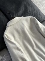 🆕- This woolen coat brings out the classic style with contemporary poetryWhen 72.1% sheep wool meets 27.9% polyester fiber, it weaves not only fabric, but also gentle armor that can withstand the test of time. The fleece surface has a fine luster, like a beach smoothed by the sea breeze. The light sand color will give off a warm luster like oatmeal Congee in the sun, and it will show the calm texture of gypsum sculpture in cloudy days.The arrangement of six buttons hides a thought-provoking rhythm - the four large buttons on the collar sound like piano accents, and the two small buttons on the hem sound like a light finish. This staggered design gives the placket a sense of rhythm amidst its regularity. The curve of the lapel is cut perfectly, which not only fits the collar shape of the shirt perfectly, but also outlines a graceful line when lifted in the wind.The round bottom patch pocket on the left chest is exquisitely crafted, with a curved bottom that makes the intervention posture more ergonomic. The slanted pockets on both sides have enough capacity to store hands, and the natural warmth of wool keeps fingertips warm even in cold winds. The most wonderful feature is the asymmetrical design of the cuffs - the outer knitted thread is windproof and warm, while the inner fabric continues the overall texture. The splicing details exposed when lifting the hand add a touch of fun.The one-piece cut on the back fully showcases the drape of the woolen fabric, and the hem forms smooth waves as you walk. The wine red lining inside is like a secret hidden in a suit, and the bright colors that catch a glimpse every time you take off are a small sense of ceremony unique to the wearer. The dual pocket design added to the side is both practical and considerate, allowing the phone and key to be placed separately without colliding with each other in the pocket.This jacket embodies the contemporary language of classic items, featuring a sturdy frame supported by polyester fibers, a soft and comfortable fit with plush wool, and asymmetrical cuffs for attention to detail. When others are still struggling with matching, this light sand colored jacket has already become the most sensible member in the wardrobe, easy to handle whether paired with jeans or trousers. In today's fast-paced fashion world, a wool jacket that can accompany you for many years but becomes even more flavorful is the true wardrobe cornerstone worth investing in.Color: Light Sand174-140 upper body size LSize: M-XXXL (48-56)Item number: FXHK8621M size bust circumference 114 shoulder width 47.8 sleeve length 60 garment length 62.5L size bust circumference 118 shoulder width 49 sleeve length 61.5 clothing length 64XL chest circumference 122 shoulder width 50.2 sleeve length 63 garment length 65.5XXL bust circumference 126 shoulder width 51.4 sleeve length 63.5 garment length 66.5XXXL bust circumference 130 shoulder width 52.6 sleeve length 64 garment length 67.5 - Image 5